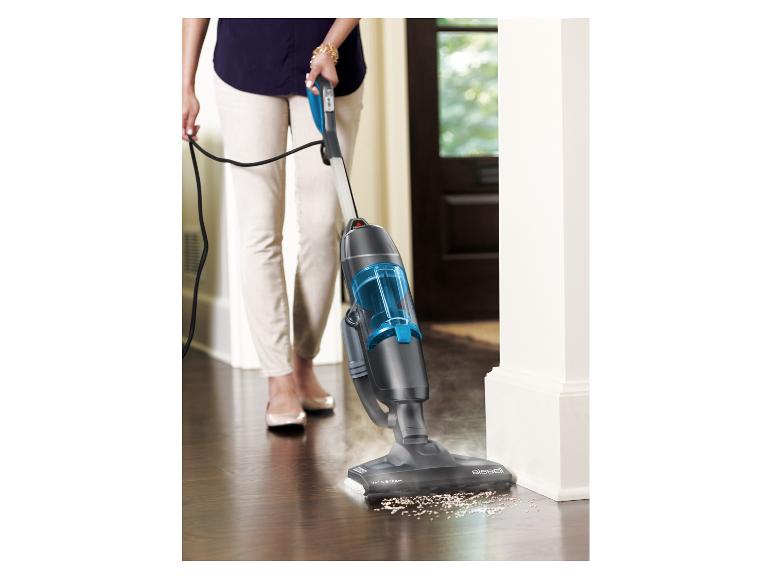 Vrouw reinigt houten vloer met een Bissell stofzuiger en stoomreiniger.