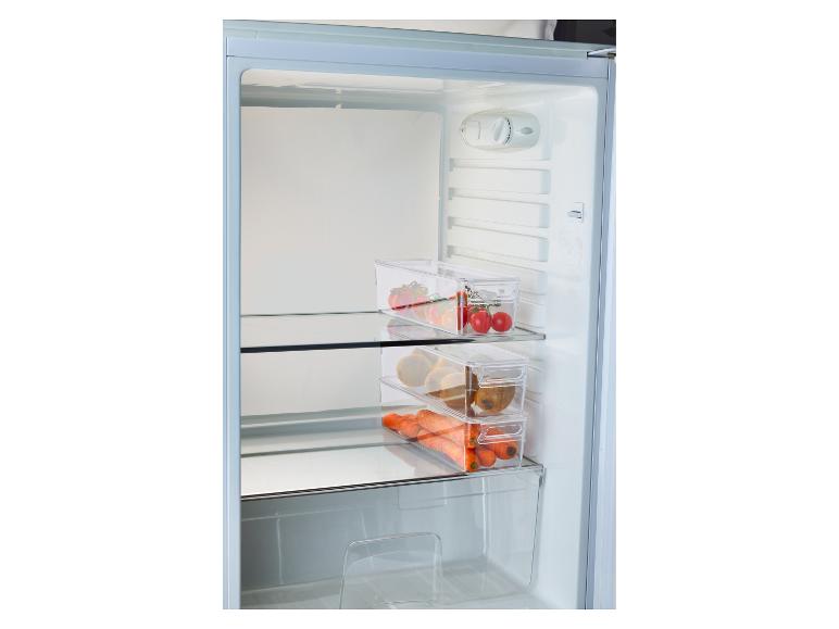 Koelkast met transparante bakjes gevuld met tomaten, kiwi's en wortels.