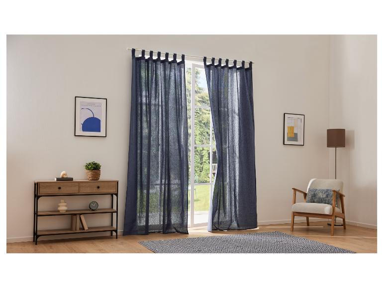 Donkerblauwe linnen gordijnen, consoletafel en design fauteuil.
