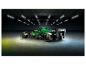 Groene Aston Martin F1 raceauto in een donkere garage met neonverlichting.