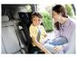 Lachende moeder en kind in een kinderzitje in de auto.