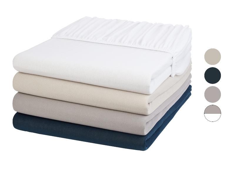 Stapel hoeslakens in neutrale kleuren.