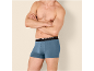 Man in blauwe boxershorts met gekruiste armen.