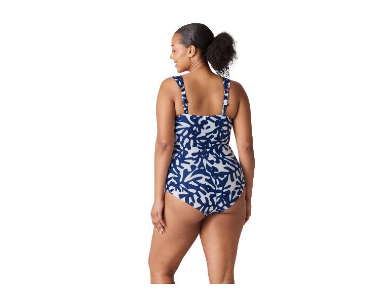Vrouw in een blauw-wit patroon badpak uit één stuk, van achteren gezien.
