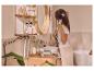 Vrouw stylet haar met een warme borstel in een moderne badkamer met haarstylingtools en cosmetica.