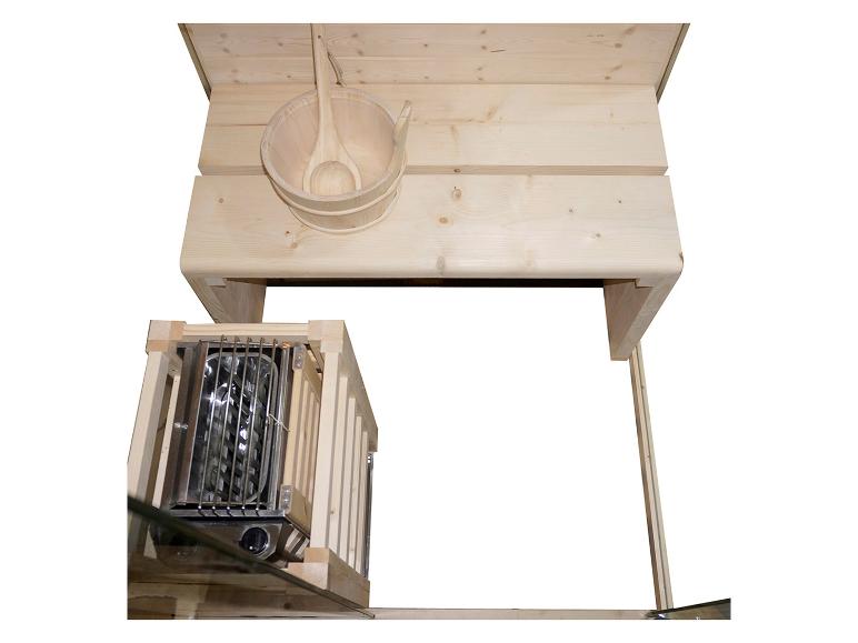Sauna-interieur met houten bank, emmer en kachel.