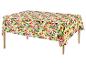 Tafelkleed met levendig tropisch bloemenpatroon op een houten tafel.