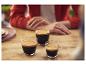 Drie dampende espresso's op een houten tafel.