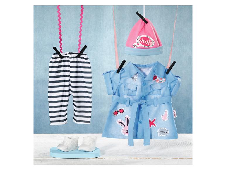 Poppenkleding: gestreepte broek, blauwe jurk met riem en roze 'Smile' muts drogend aan een lijn.
