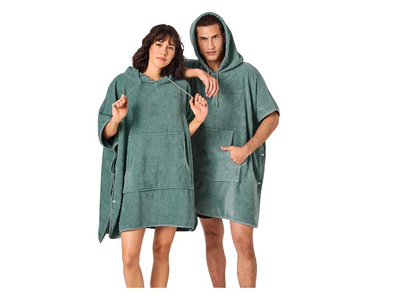 Twee personen in groene badstof poncho's met capuchon en zakken.