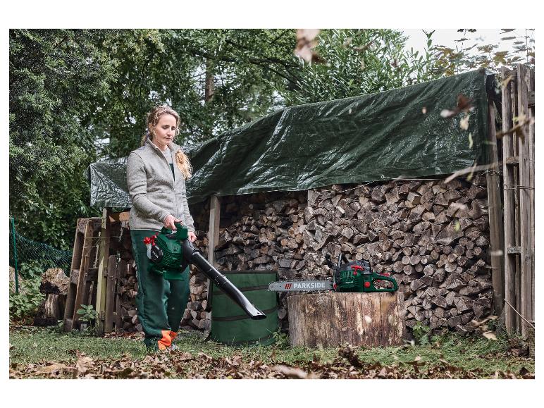 Vrouw gebruikt bladblazer, met kettingzaag op een houtblok.
