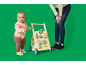 Baby met loopwagen en een volwassene op de achtergrond