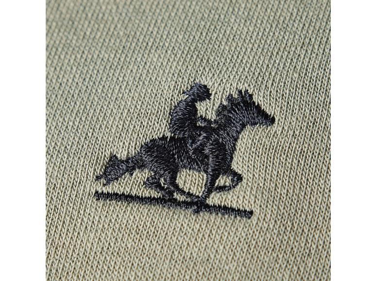 Beige stof met geborduurd motief van een jockey op een paard.