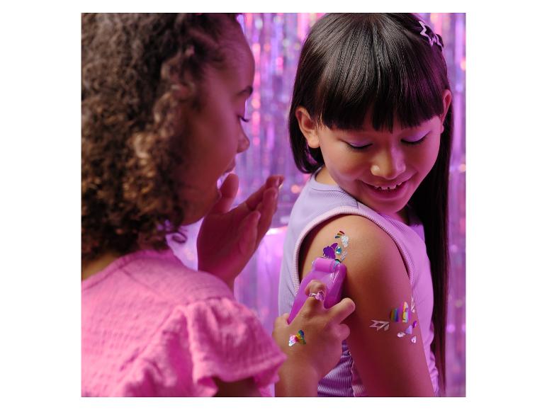 Twee meisjes brengen tijdelijke tatoeages en edelstenen aan op elkaars armen.