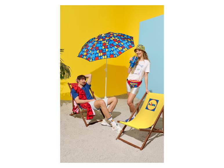 Man en vrouw op strand met parasol, strandstoel, heuptas en thermobeker.