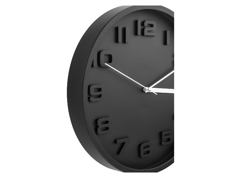 Moderne zwarte wandklok met reliëfcijfers.