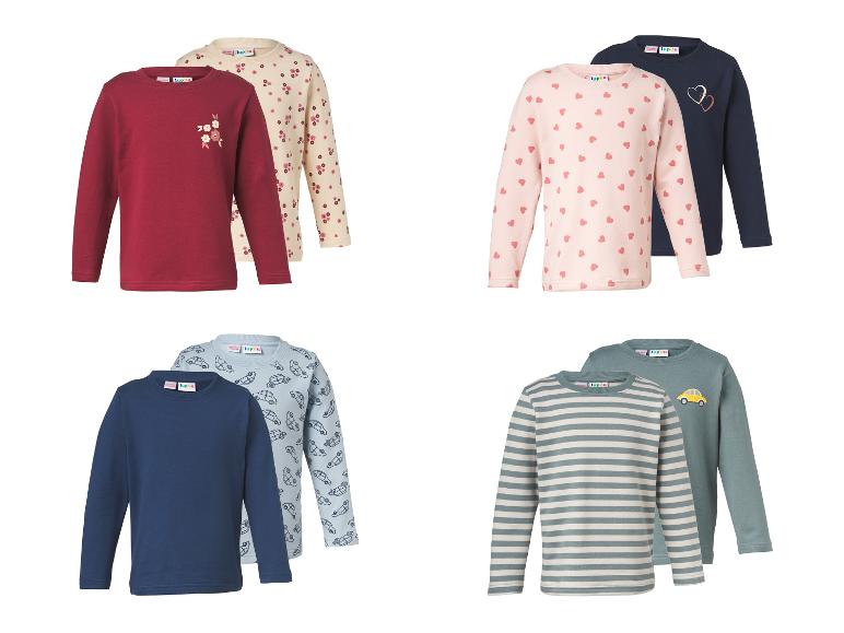 Vier sets van twee kinderlongsleeves, met bloemen-, harten-, auto- en streepmotieven.