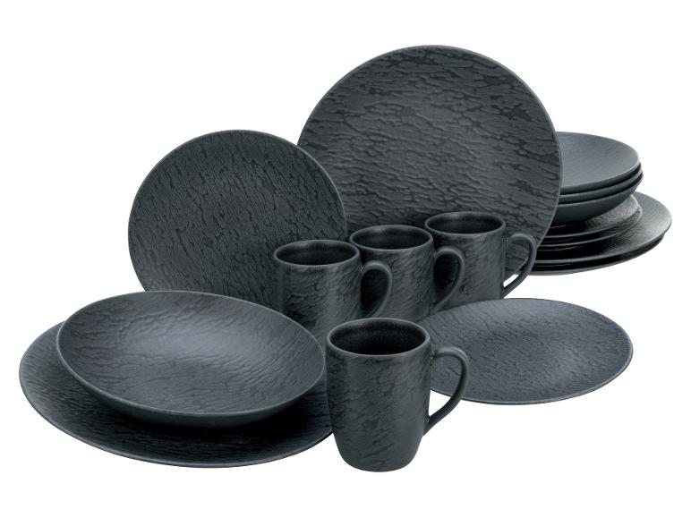 Zwart steengoed servies met getextureerde borden, kommen en mokken.