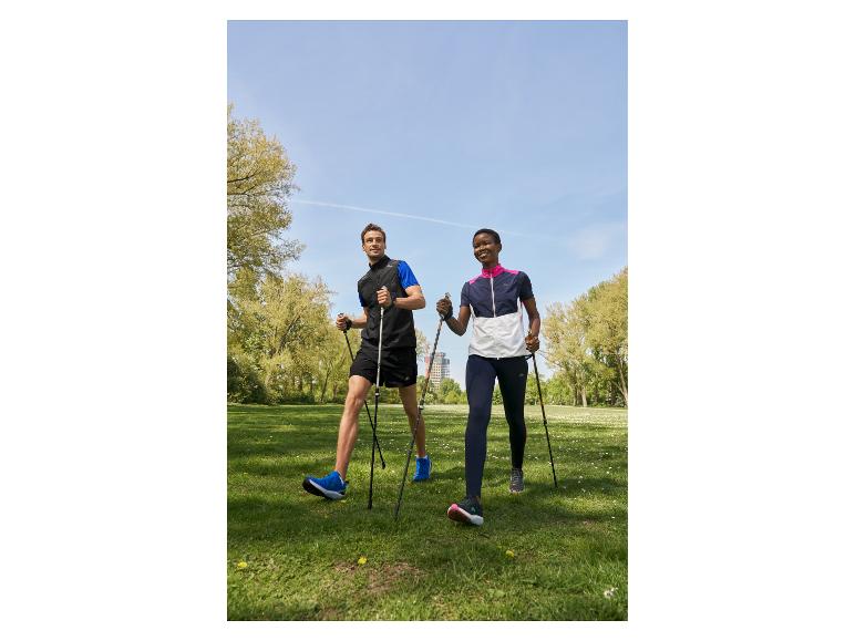 Twee personen nordic walken in een park.