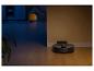 Robotstofzuiger op een houten vloer, half in het donker, half verlicht.