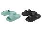 Groene slippers en zwarte sandalen op een witte achtergrond.