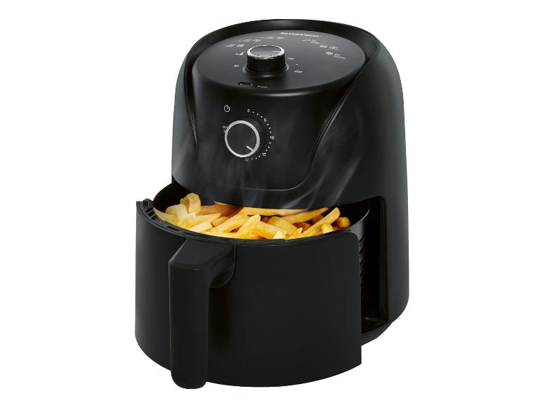 Een zwarte airfryer van Silvercrest met gebakken frietjes.