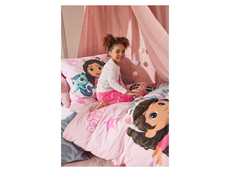 Roze Gabby's Dollhouse beddengoed en een lachend meisje.