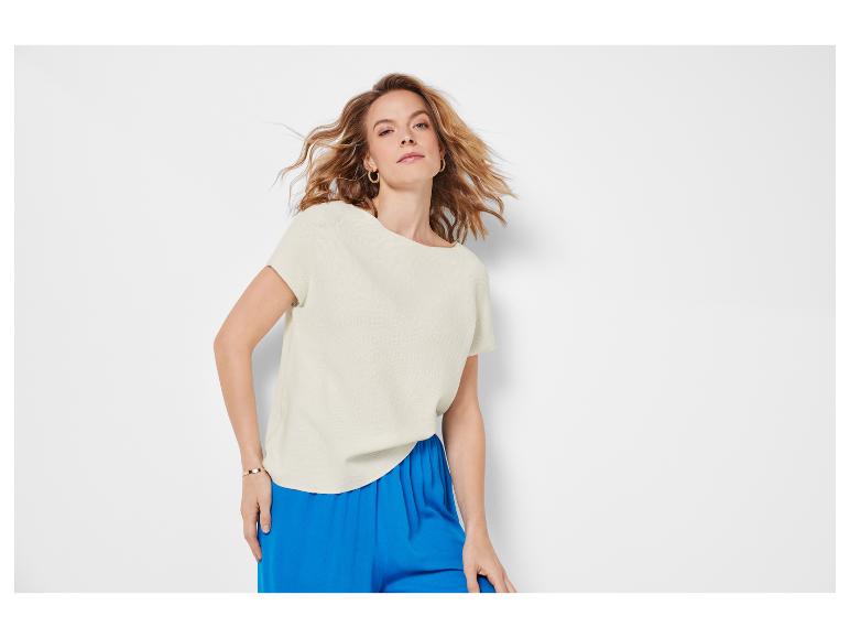 Vrouwelijke crèmekleurige top met korte mouwen en kobaltblauwe broek.