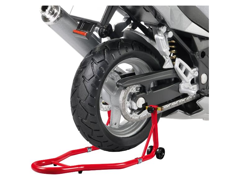 Achterkant van een motorfiets op een rode standaard, met band, ketting en uitlaat