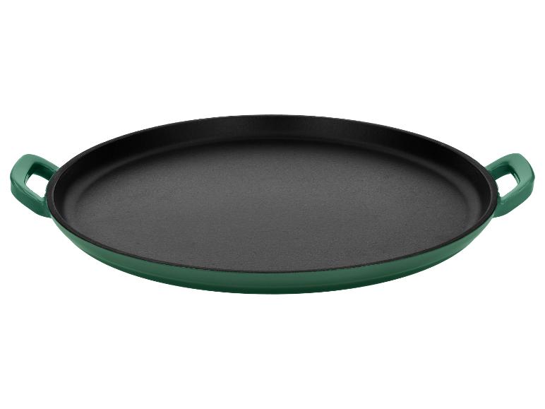 Groene gietijzeren paellapan met zwarte binnenkant.