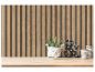 Houten lattenwandpaneel met een plant, decoratieve ampersand en gestreepte potten op een plank.