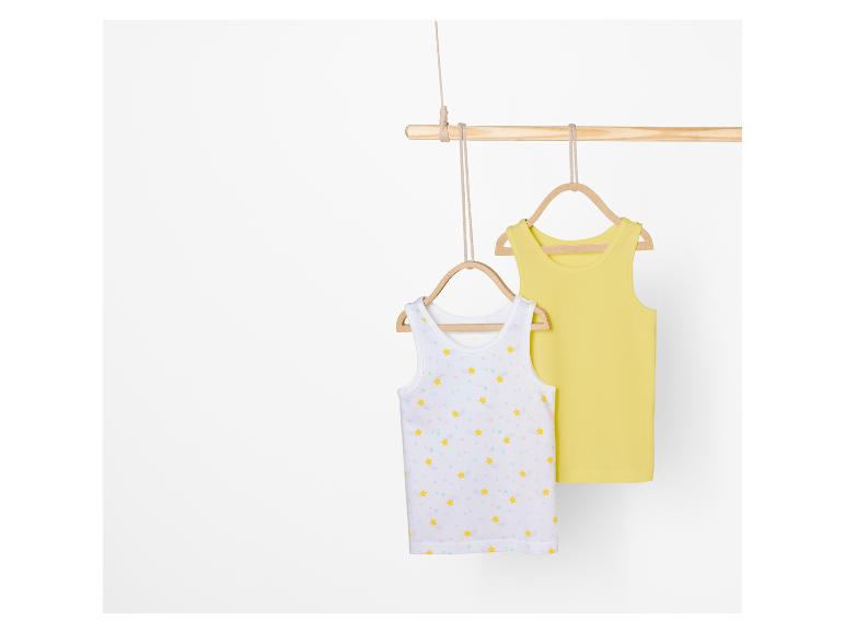 Twee tanktops voor meisjes, één met sterrenprint en één effen geel.