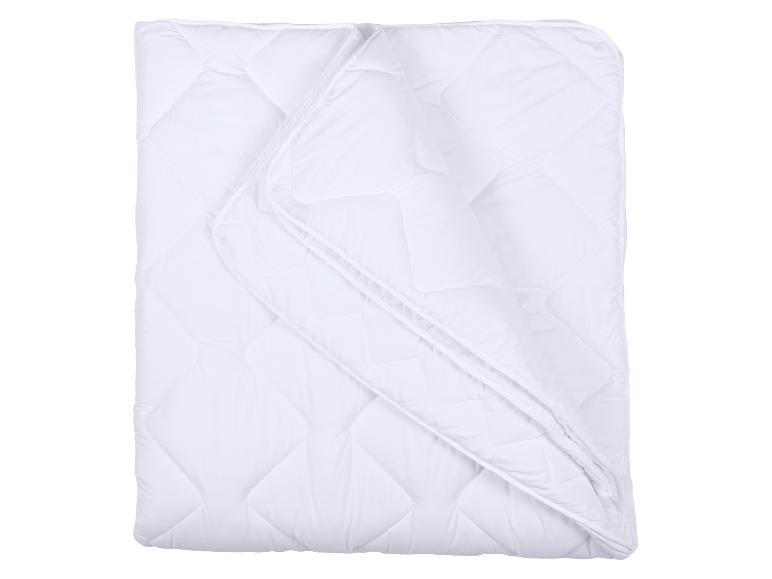 Wit gewatteerd dekbed, opgevouwen, met een zichtbare bies.
