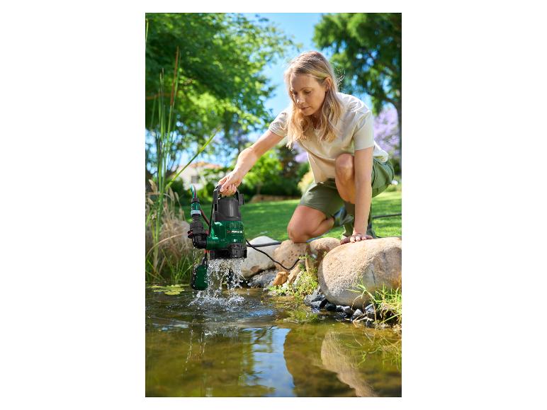 Vrouw gebruikt dompelpomp om tuinvijver schoon te maken.