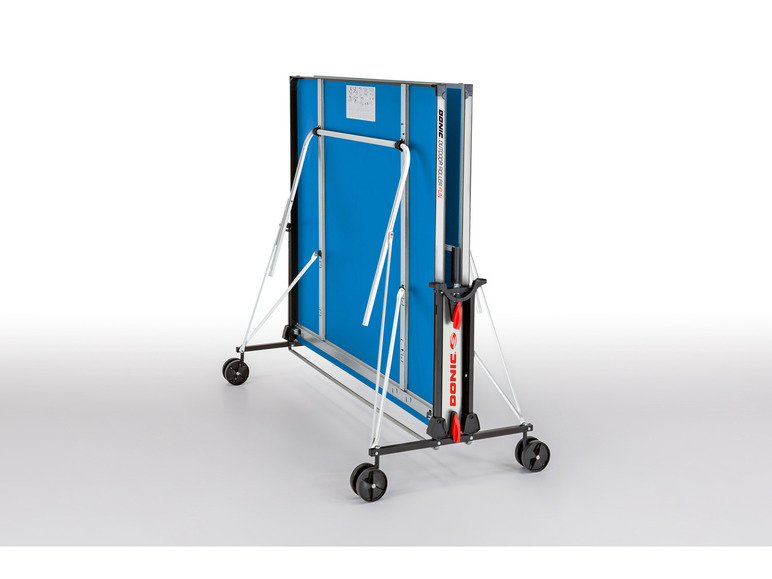 Een blauwe tafeltennistafel van Donic met wielen, opgevouwen en klaar om te worden opgeslagen.