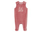 Een roze baby overall met een giraffe print.