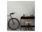 Fiets en bureau met decoratieve items tegen een gestructureerde muur.