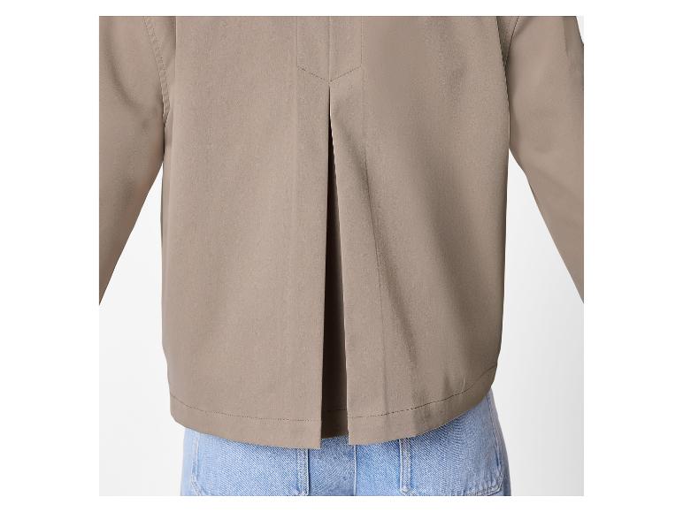 Achteraanzicht van een beige damesblouse met een plooi, gedragen over een blauwe jeans.