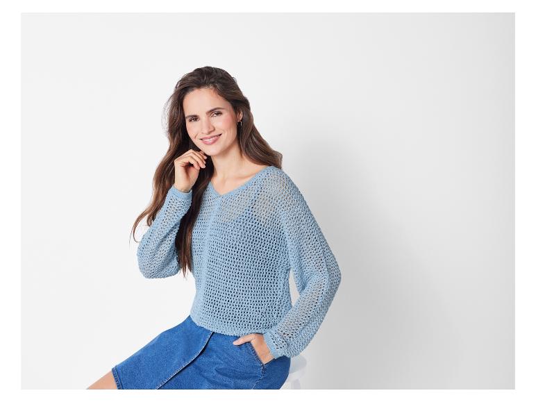 Lichtblauwe opengewerkte trui en jeans rok.