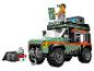 Een LEGO City set met een groen verkenningsvoertuig en een minifiguur met verrekijker en kaart.