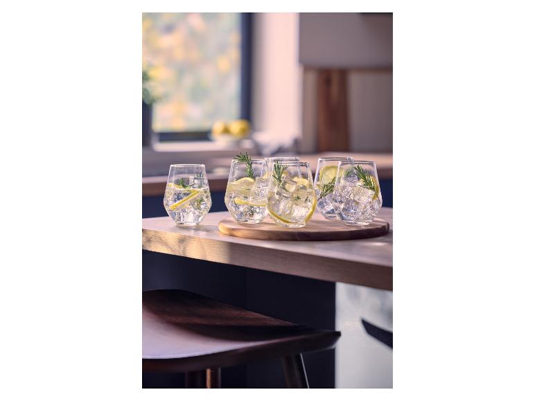 Glazen met verfrissende drank, ijs, citroen en rozemarijn op een houten tafel.