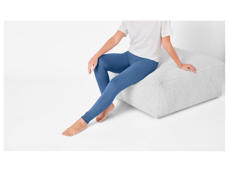 Blauwe leggings en een lichtgrijze corduroy pouf.