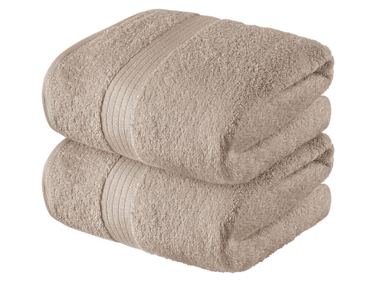 Twee beige handdoeken, opgevouwen.