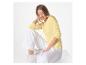Vrouw in geel shirt met lange mouwen en witte broek, zittend.