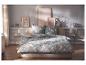 Slaapkamer met bed met bloemig beddengoed, nachtkastjes en schilderijen aan de muur.