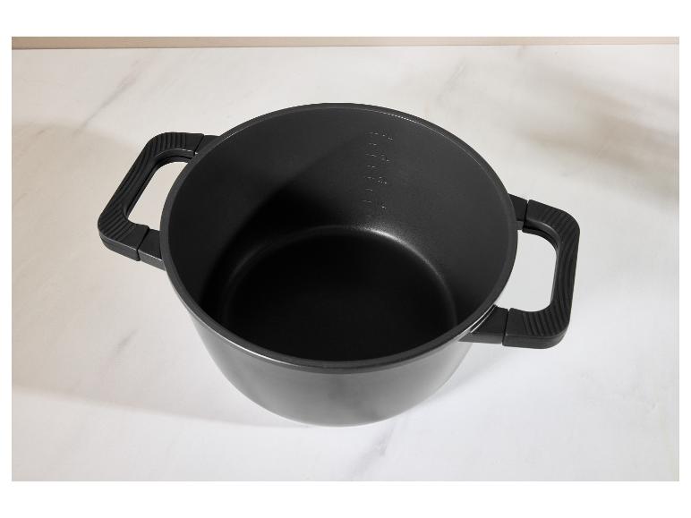 Zwarte kookpan met handvatten en maatstreepjes op een wit oppervlak