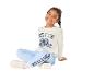 Lachend meisje in sweatshirt en joggingbroek met cartoonfiguurprint