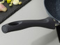 Een zwarte pan met een soft-touch handvat.