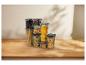 Doorzichtige voedselcontainers met pasta, noten en koffiebonen op een houten tafel.