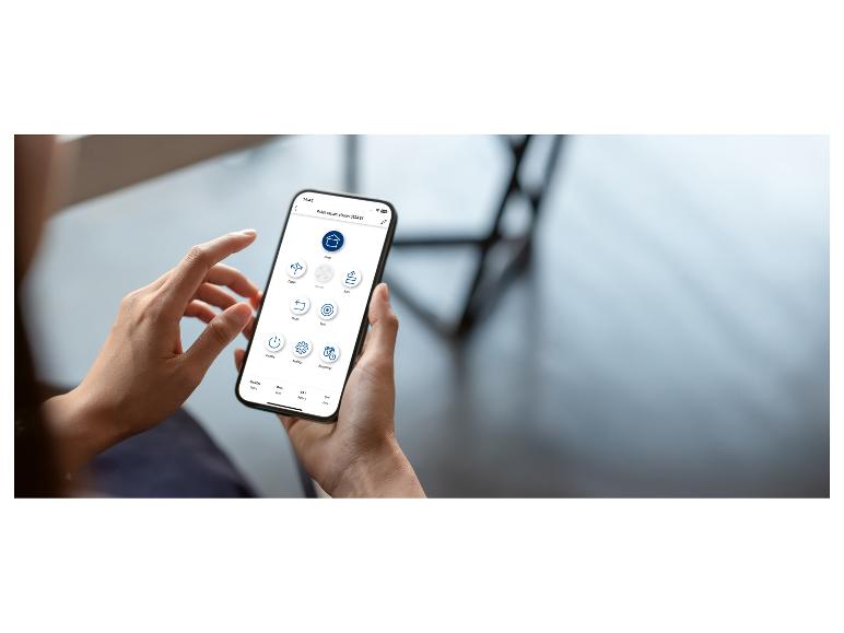 Een persoon houdt een smartphone vast met een robotstofzuiger-app met diverse bedieningsopties.